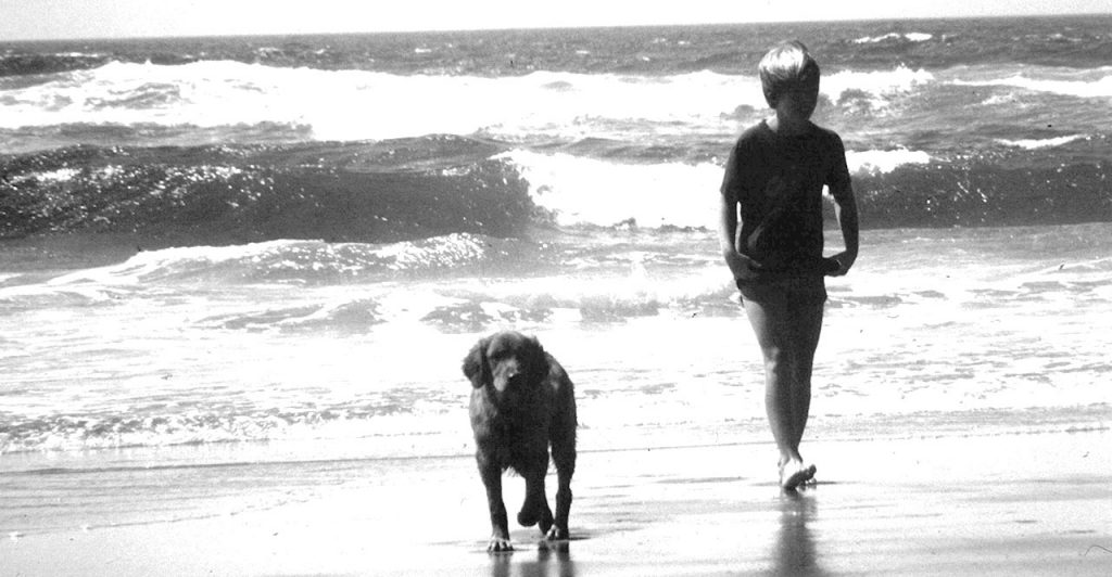 Young me and my dog walking on the beach back in the '80s